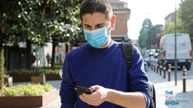 Man wearing face mask using smartphone