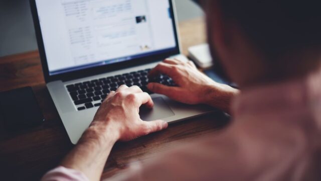 man browsing online on a laptop