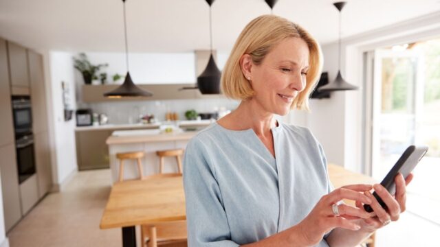 woman smiling holding a smartphone