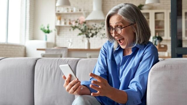 older woman excited looking at her phone