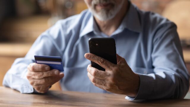 man on his phone with a credit card