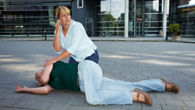 passerby making an emergency call with unconscious woman's phone