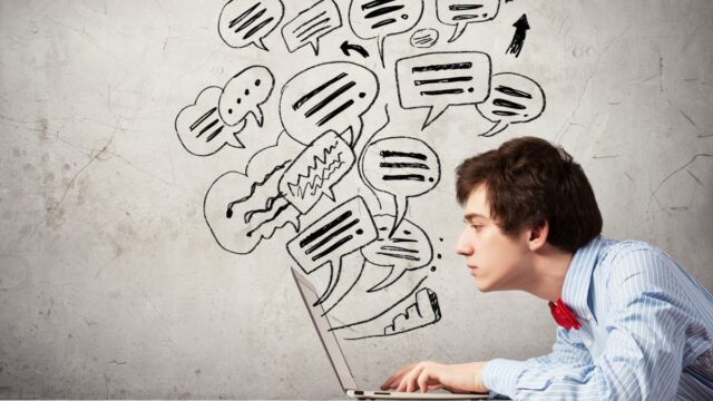 young man typing on laptop with messages flying in the air