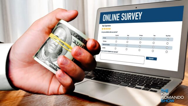 hand holding roll of cash in front of laptop showing online survey