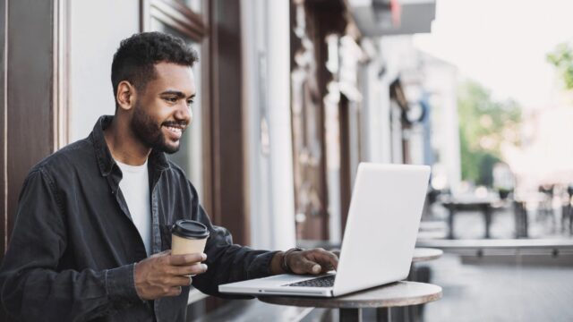 man on mac laptop in public