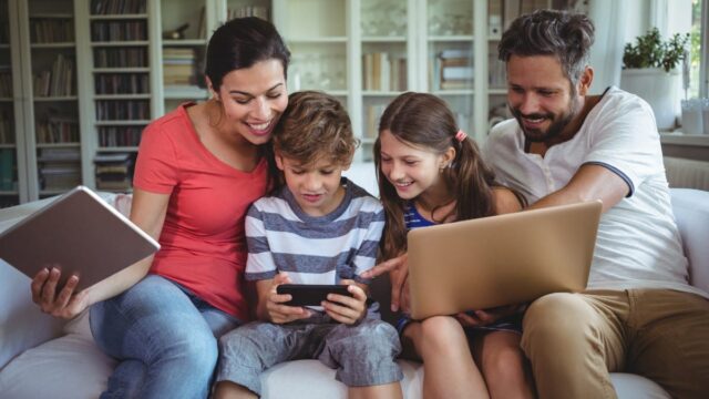 family playing with tablets and phone